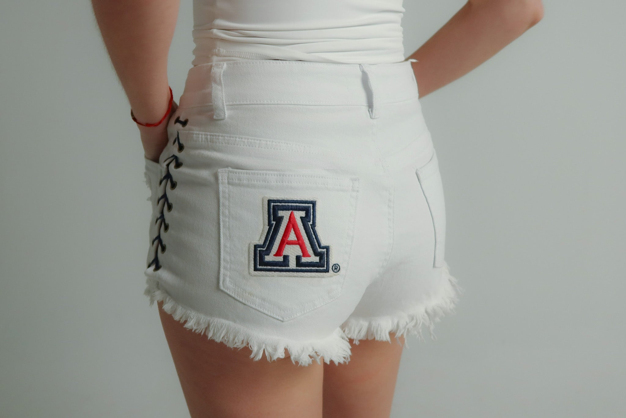 white lace-up denim shorts styled for University of Arizona football game day outfit for women
