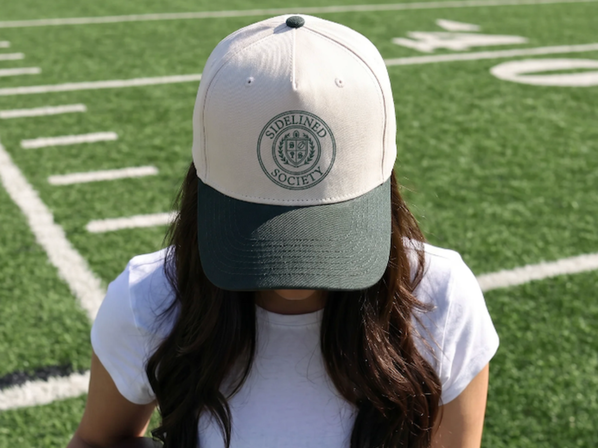 Sidelined Society trucker crest hat on football field for game day