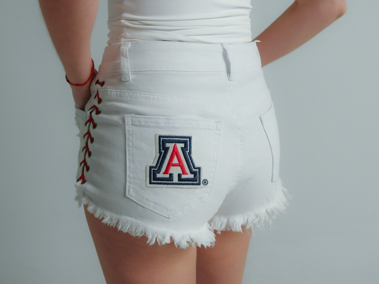 white University of Arizona women’s game day denim shorts with lace-up sides, frayed hem, and Arizona Wildcats logo on back pocket